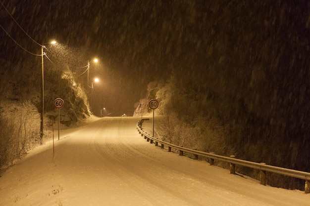 Verlichte sneeuwbedekte weg's nachts