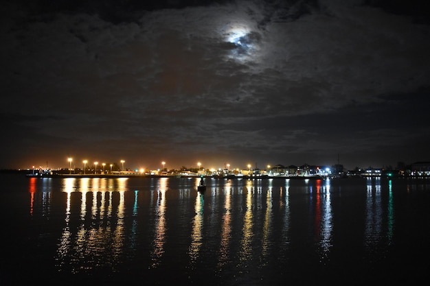 Foto verlichte stad aan zee tegen de hemel 's nachts