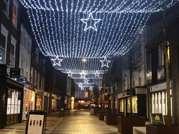 Verlichte straat te midden van gebouwen in de stad 's nachts