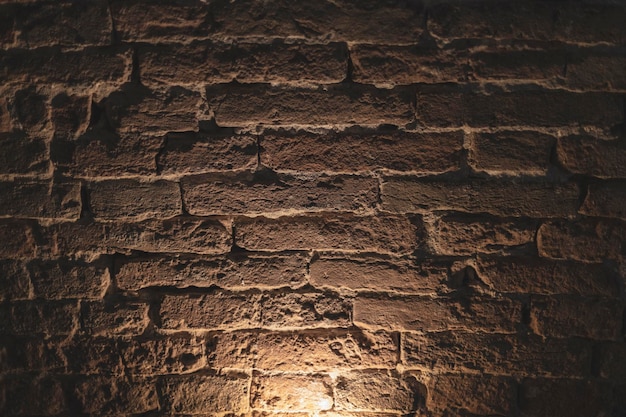 Verlichting naar boven op oude bakstenen muur creëert een dramatisch effect