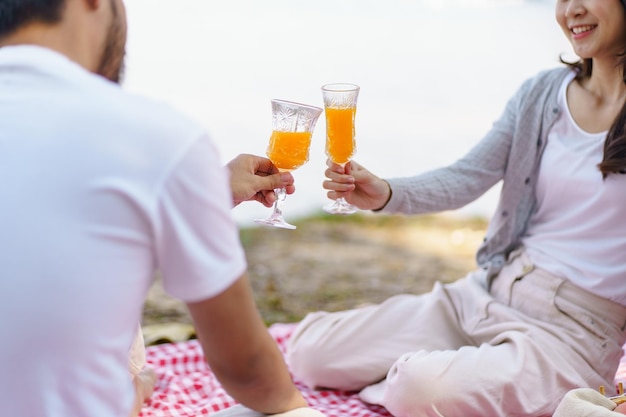 Verliefd aziatisch paar genieten van picknicktijd in het park buiten Picknick gelukkige paar ontspannen samen met picknickmand