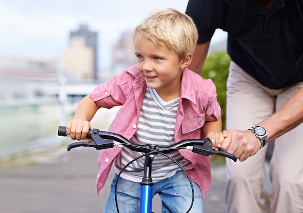 Verliefd op zijn eerste fiets Een vader die zijn jonge zoon leert fietsen