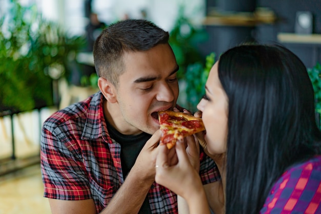 Verliefd stel eet stuk hete pizza