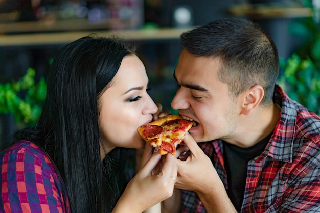 Verliefd stel eet stuk hete pizza