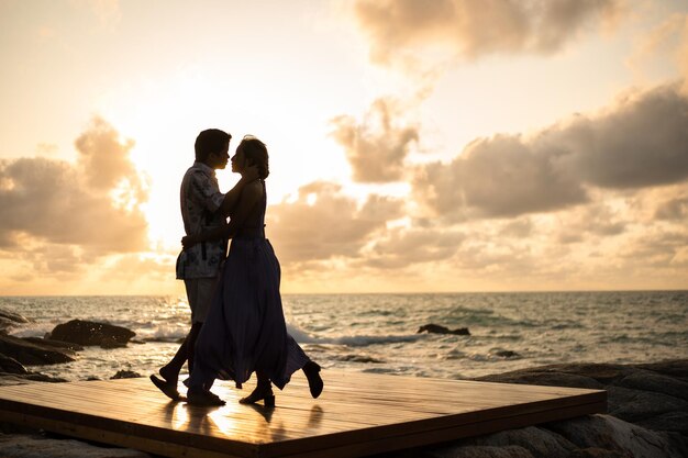 Verliefd stel omhelst elkaar op het strand en geniet van een romantisch moment bij zonsondergang