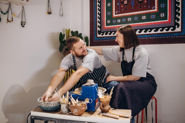 Verliefd stel werkt samen aan pottenbakkerswiel in ambachtelijke studio-workshop