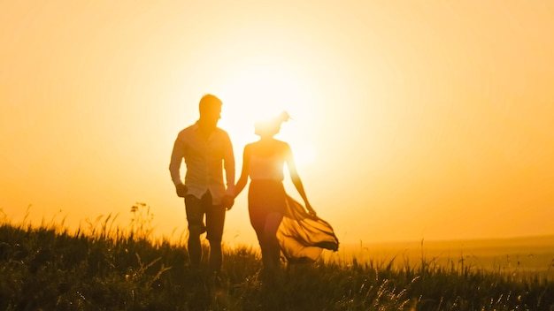 Verliefde paar dappere jonge man en mooi meisje bij zonsondergang silhouet