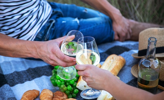 Verliefde paar drinkt wijn op een picknick. Selectieve aandacht. Natuur