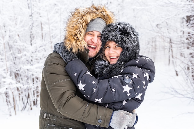 Verliefde paar hebben plezier in het besneeuwde bos. Actieve wintervakantie.