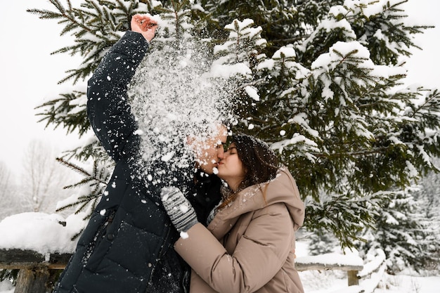 Verliefde paar in puffer jas op een winterwandeling. Man en vrouw hebben plezier in het ijzige bos. Romantische date in de winter.Kerststemming van een jong gezin.Winter liefdesverhaal