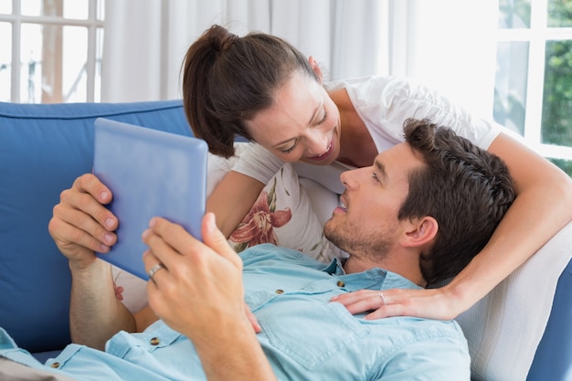 Verliefde paar met digitale tablet in de woonkamer