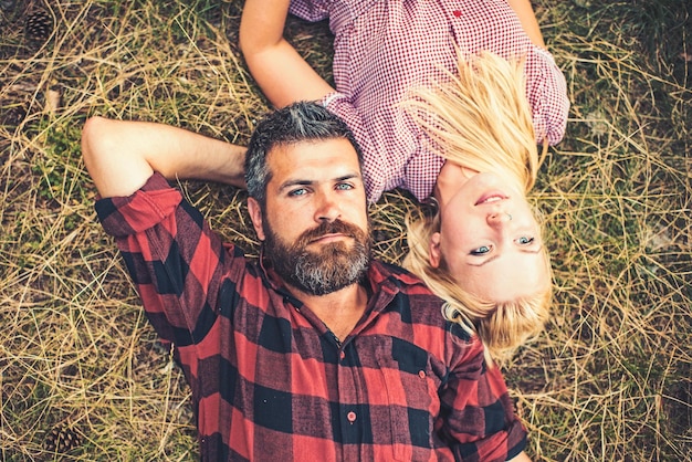 Verliefde paar ontspannen op groen gras Bebaarde man en vrouw met lang blond haar Hipster en meisje genieten van zomerdag op de natuur Zomervakantie concept liefde romantiek en familie