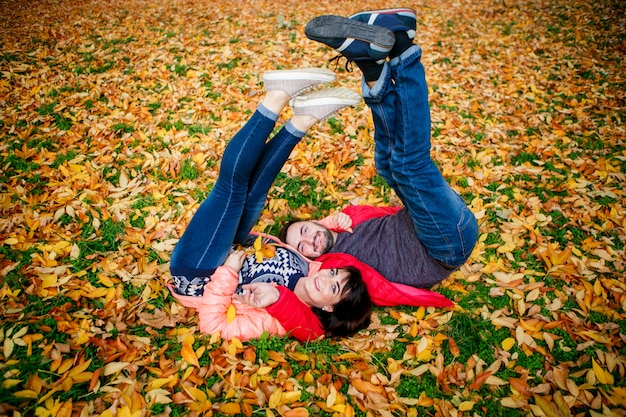 Verliefde paar ontspant op herfstbladeren in het park