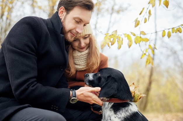 Foto verliefde paar wandelen door het herfstbos park met een spaniel hond