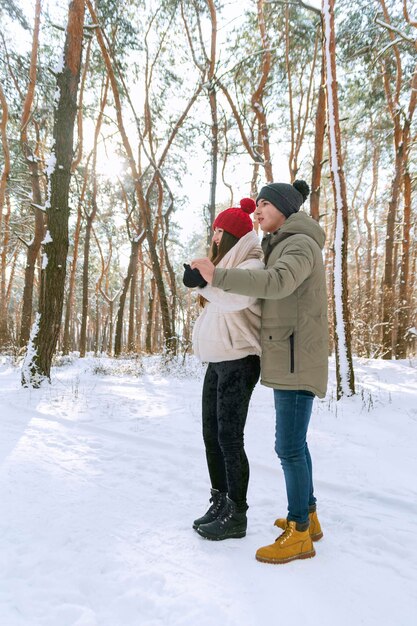 Verliefde paar wandelingen door winterpark. Guy en haar vriendin genieten van een zonnige winterdag. Zijaanzicht