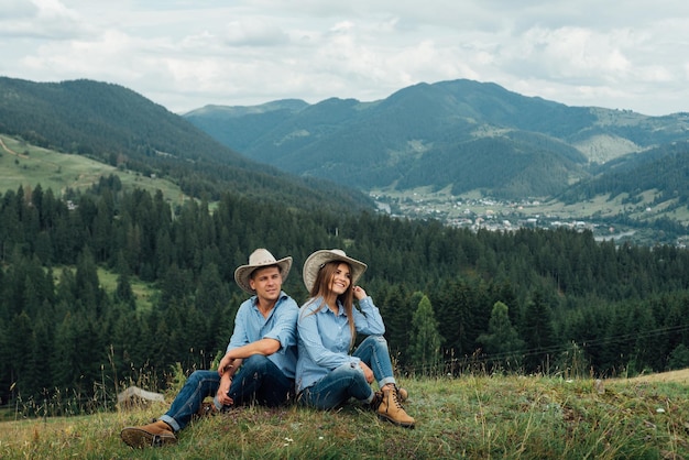 Verliefde paar zittend op bergweide en genieten van uitzicht op de natuur