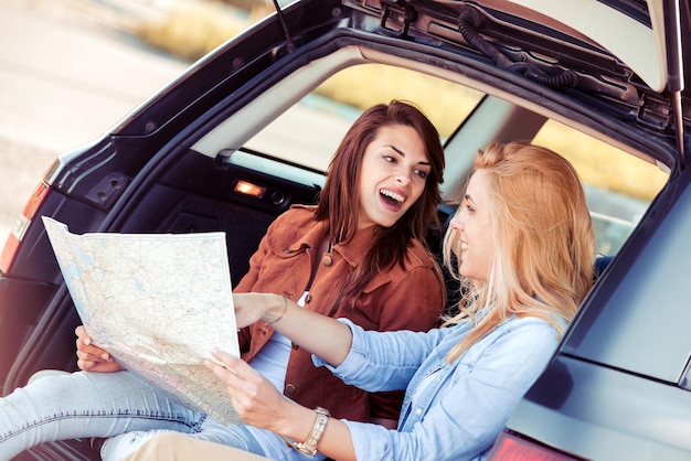 Verloren met kaarttwee jonge vrienden in auto genieten van roadtrip