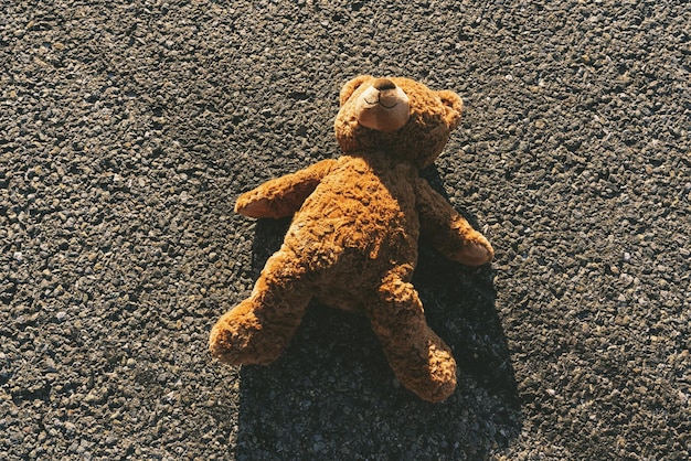 Verloren teddybeer liggend op straat na een ongeval, met skidmarks