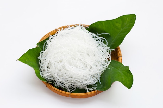 Vermicelli su foglia di taro su cesto di bambù su sfondo bianco.