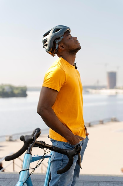 Vermoeide Afro-Amerikaanse man die bij zijn fiets op straat staat
