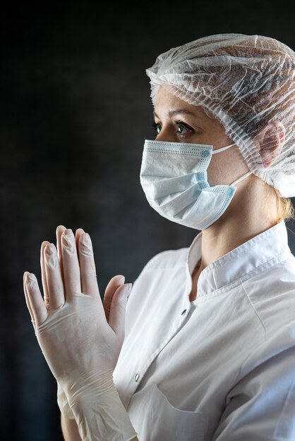 vermoeide blanke vrouwelijke dokter bidden in het ziekenhuis