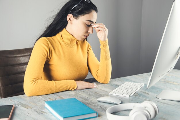 Vermoeide jonge vrouw in de werktafel