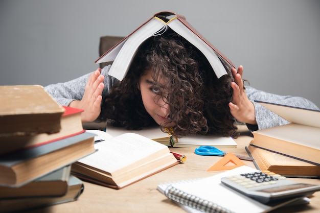 Foto vermoeide meisjesstudentenboeken in hoofd.