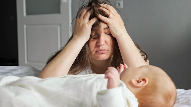 Vermoeide moeder zorgt voor pasgeboren meisje dat hoofdpijn probeert te negeren