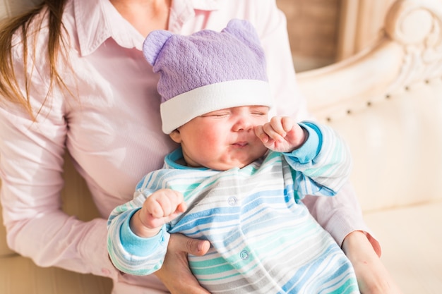 Vermoeide pasgeboren babyjongen die in de ogen wrijft