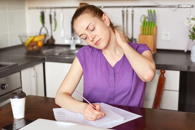 Vermoeide schattige vrouw heeft pijn in de nek