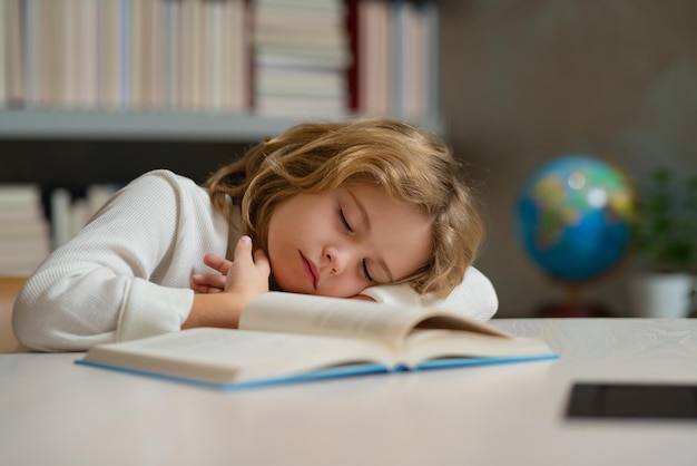Vermoeide schooljongen verveelde leerling slapen op school school en onderwijsconcept