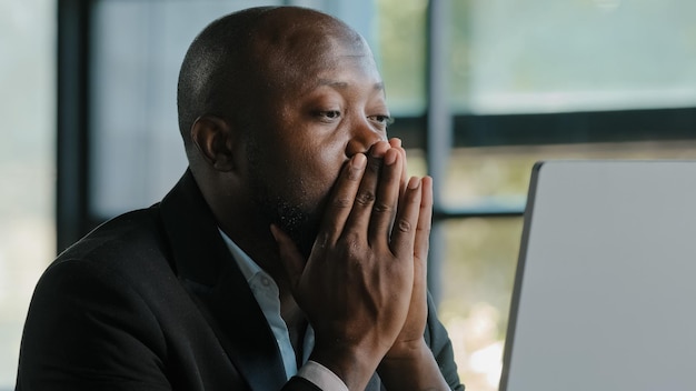 Vermoeide stressvolle Afrikaanse mannelijke volwassen trieste zakenman voelt vermoeidheid ongemak vermoeide ogen vermoeidheid pijn