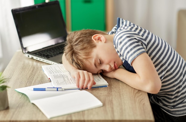 vermoeide student die thuis op zijn bureau slaapt