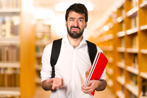 Vermoeide student man op defocused bibliotheek