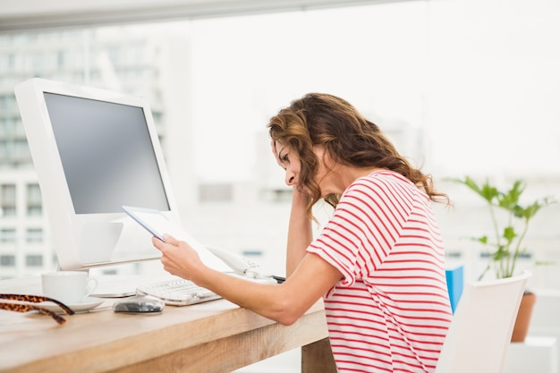 Vermoeide toevallige onderneemster die met tablet werkt