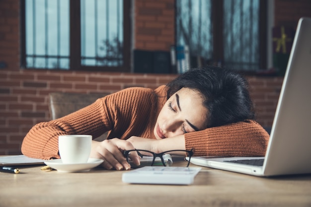 Vermoeide vrouw op bureauachtergrond