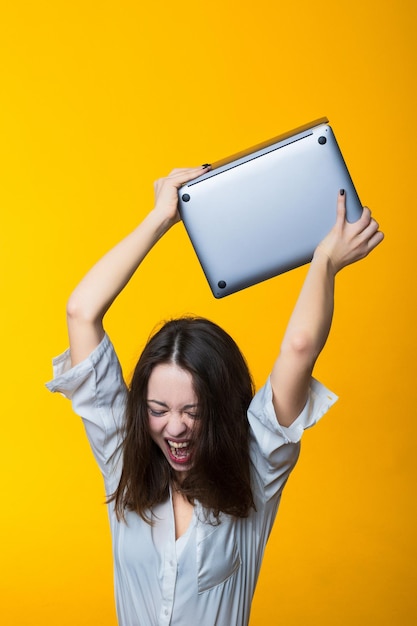 Vermoeidheid op het werk Jonge vrouw wil laptop kapot maken