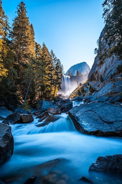 Vernal Falls waterfall of Yosemite National Park from the water that falls on the stones, long exposure vertical photo. California, United States