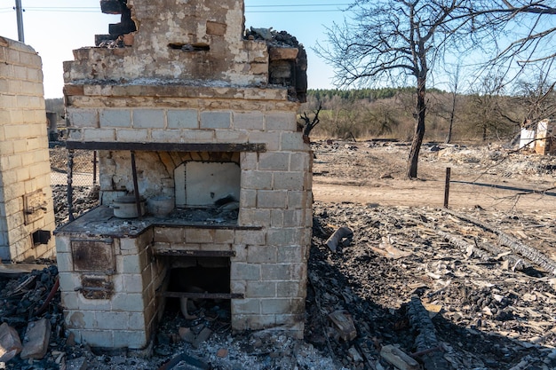 Vernietigde huizen als gevolg van een brand in Rusland Bakstenen en delen van muren verschillende huishoudelijke artikelen gebroken ramen bedekt met as liggen op het aardoppervlak Natuurramp