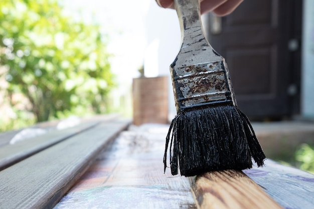 Vernissen van houten meubelen voor deuren verf een houten plank met een borstel