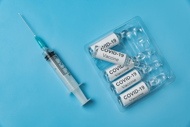 Verpakken van ampullen met vaccin COVID-19 en spuit