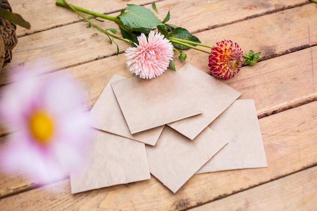 Verpakking vierkante enveloppen met plantenzaden op een houten tafel met bloemen