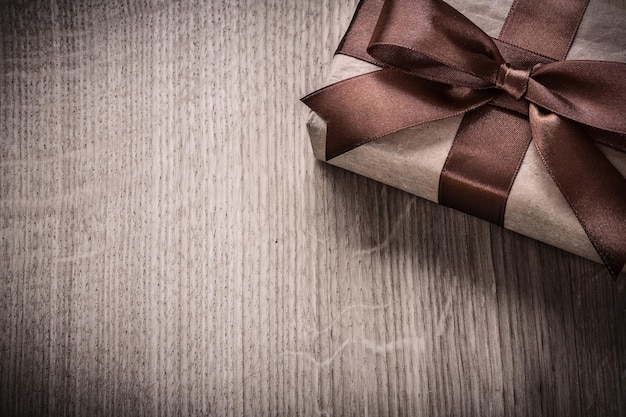 Verpakt geschenkdoos met bruine strik op houten plank viering concept