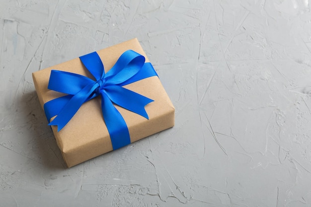 Verpakt kerst- of ander met de hand gemaakt cadeau voor de feestdagen in ambachtelijk papier met gekleurd lint Huidige doosdecoratie van cadeau op tafelblad met kopieerruimte