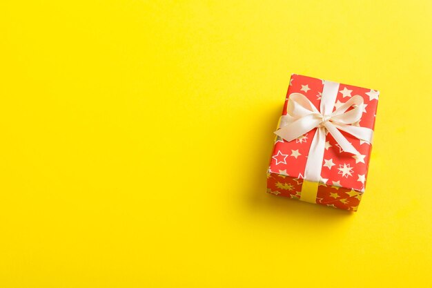 Verpakt kerst- of ander met de hand gemaakt cadeau voor de feestdagen in papier met gekleurd lint Huidige doosdecoratie van cadeau op tafelblad met kopieerruimte