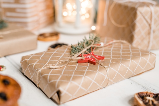 Verpakte en ingepakte geschenkdoos met rode ster en conifeer erop, klaar voor kerstmis voor een van de gasten of vrienden