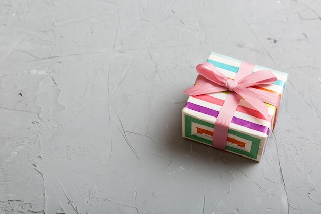 Verpakte kerst of andere handgemaakte geschenkdoos voor vakantie in gekleurd papier met lint op gekleurde achtergrond Huidige doosdecoratie van geschenk op gekleurde tafelbladweergave met kopieerruimte