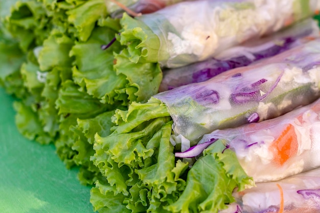 Verpakte rijstnoedels groene sla blad wortel en blauwe kool close-up Verse broodjes met rijstnoedels verpakt in sla en rijstpapier met kruiden Thaise keuken populair eten in Thailand