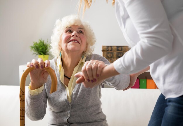 Verpleegkundige helpt oudere vrouw op te staan