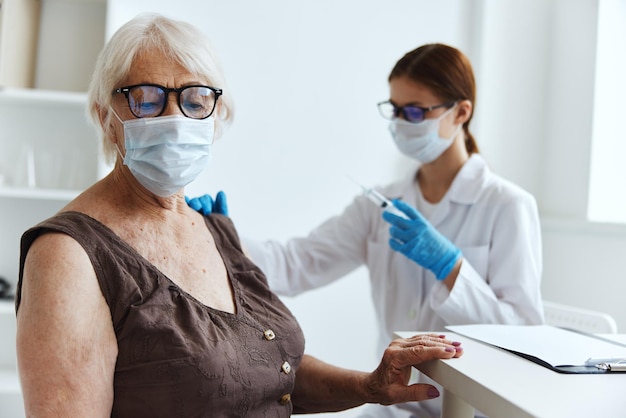 Verpleegkundige in witte jas vaccinatie van een oudere vrouw gezondheidszorg